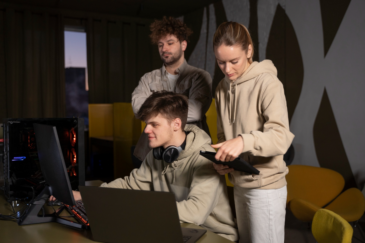 three individuals together one playing and other analyzing the game