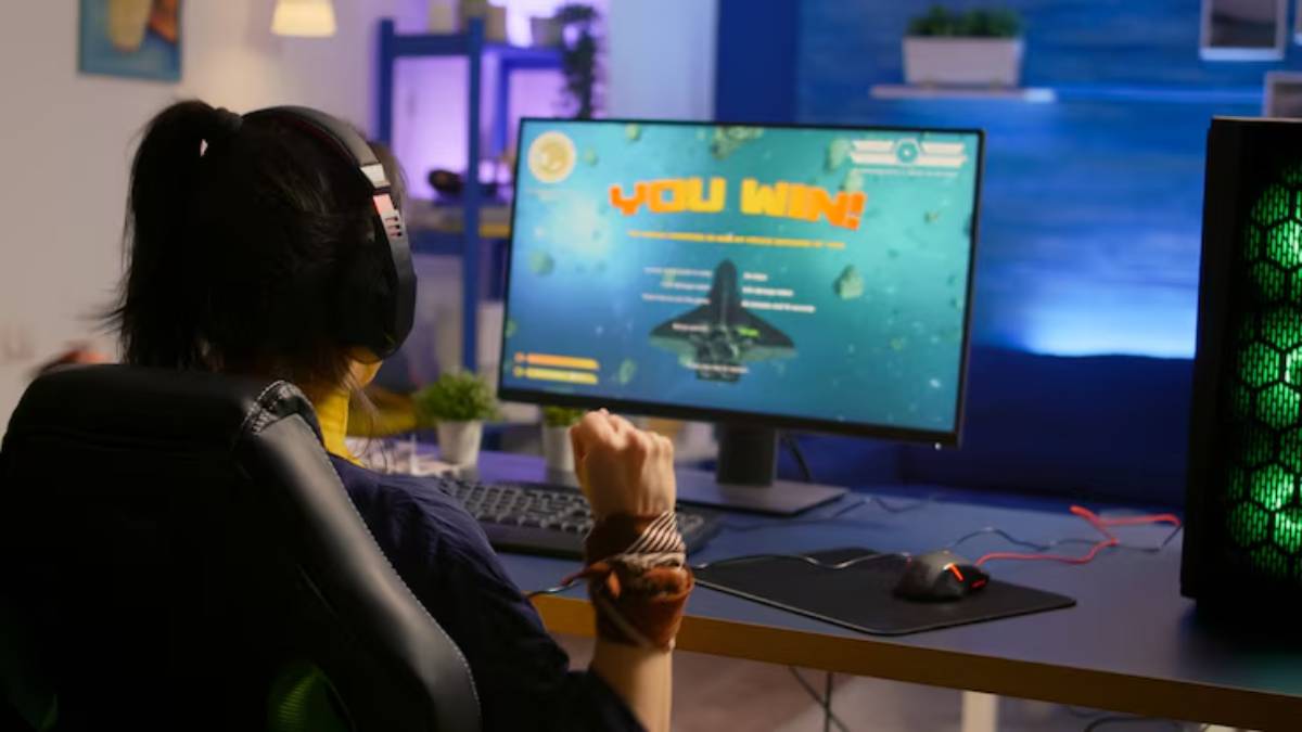 A gamer celebrates victory, fist raised, while wearing headphones, with 