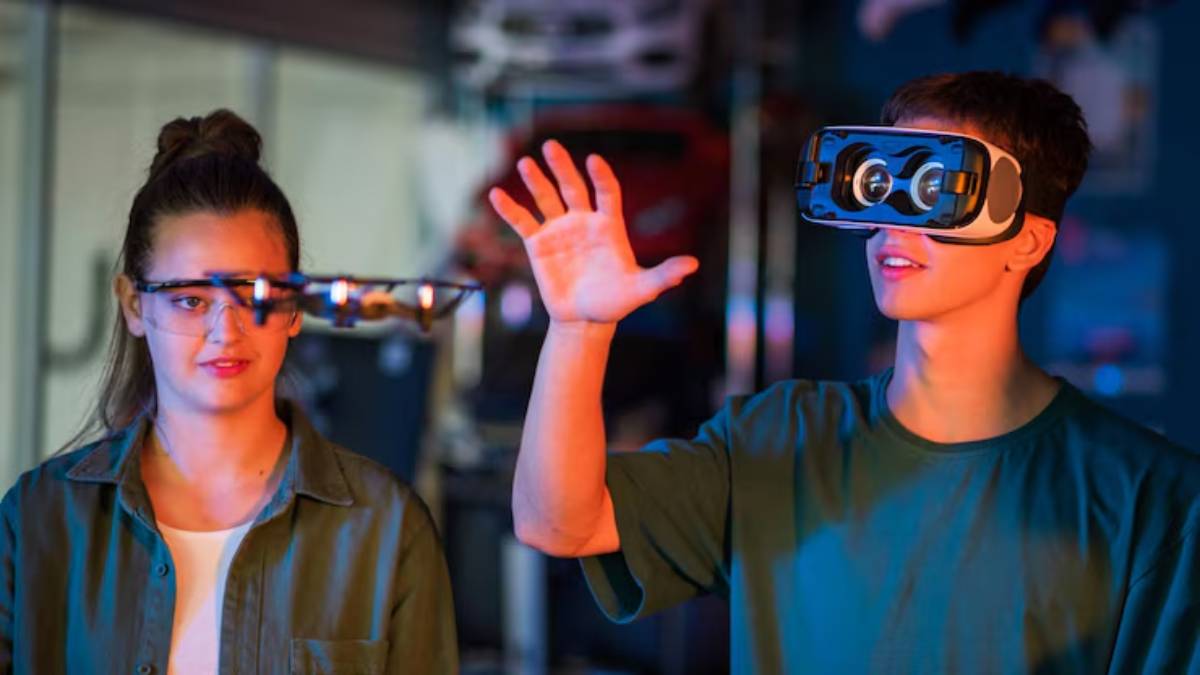 A man wearing a virtual reality headset interacts with an unseen object while a woman watches, both in a colorful, tech-filled space.