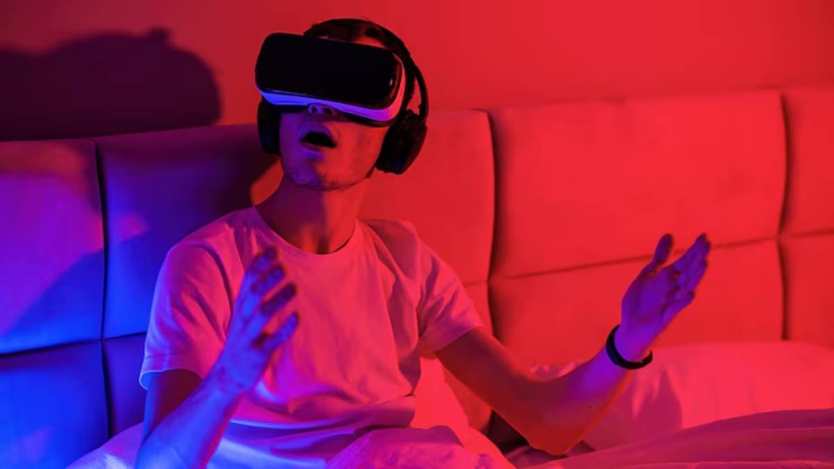  A person wearing headphones and gesturing in an immersive gaming or virtual reality setup, illuminated by colorful lights.